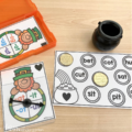 A St. Patrick's Day themed spin and cover activity is being used with plastic gold coins and a clear spinner.