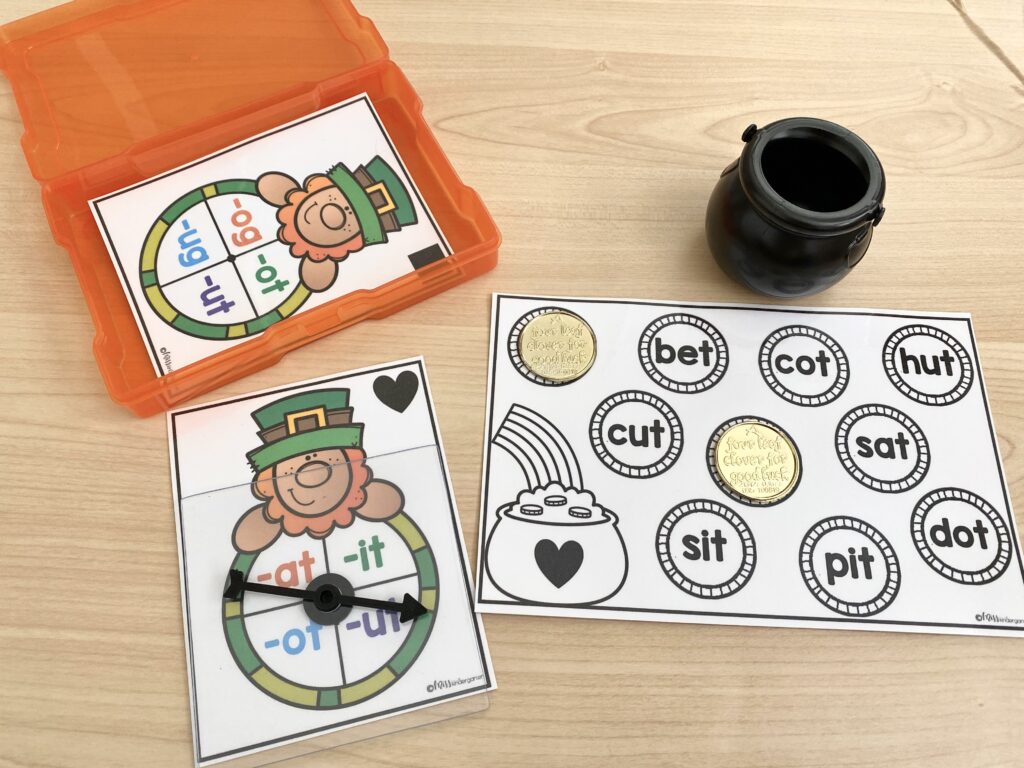 Leprechaun themed CVC word reading centers activity is shown in use on a desk. Gold coins have been added to words on the activity mat.