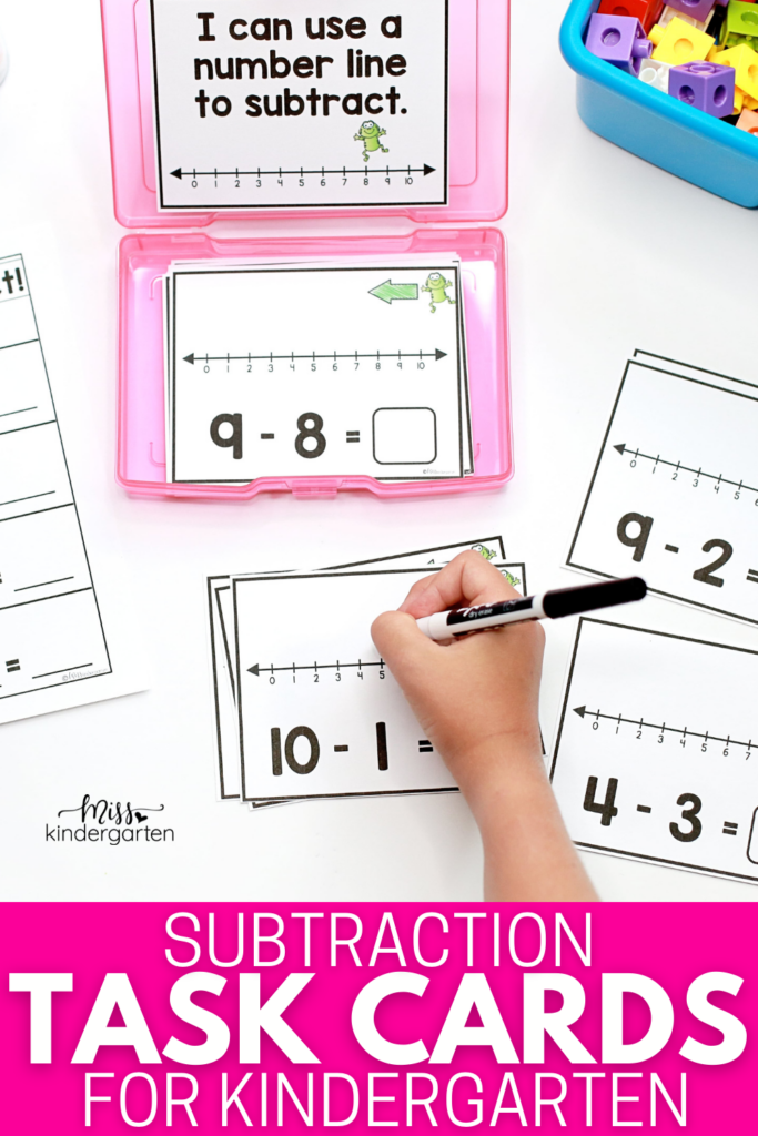 Student is completing a subtraction task card with a dry erase marker. Pink text box says "Subtraction Task Cards for Kindergarten."