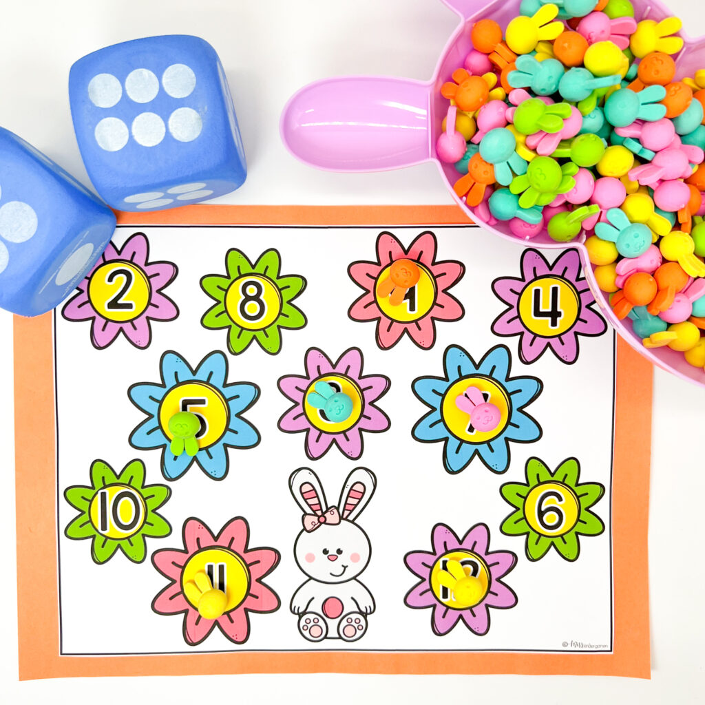 Small bunny head erasers and large foam dice are being used for a roll and cover addition activity.