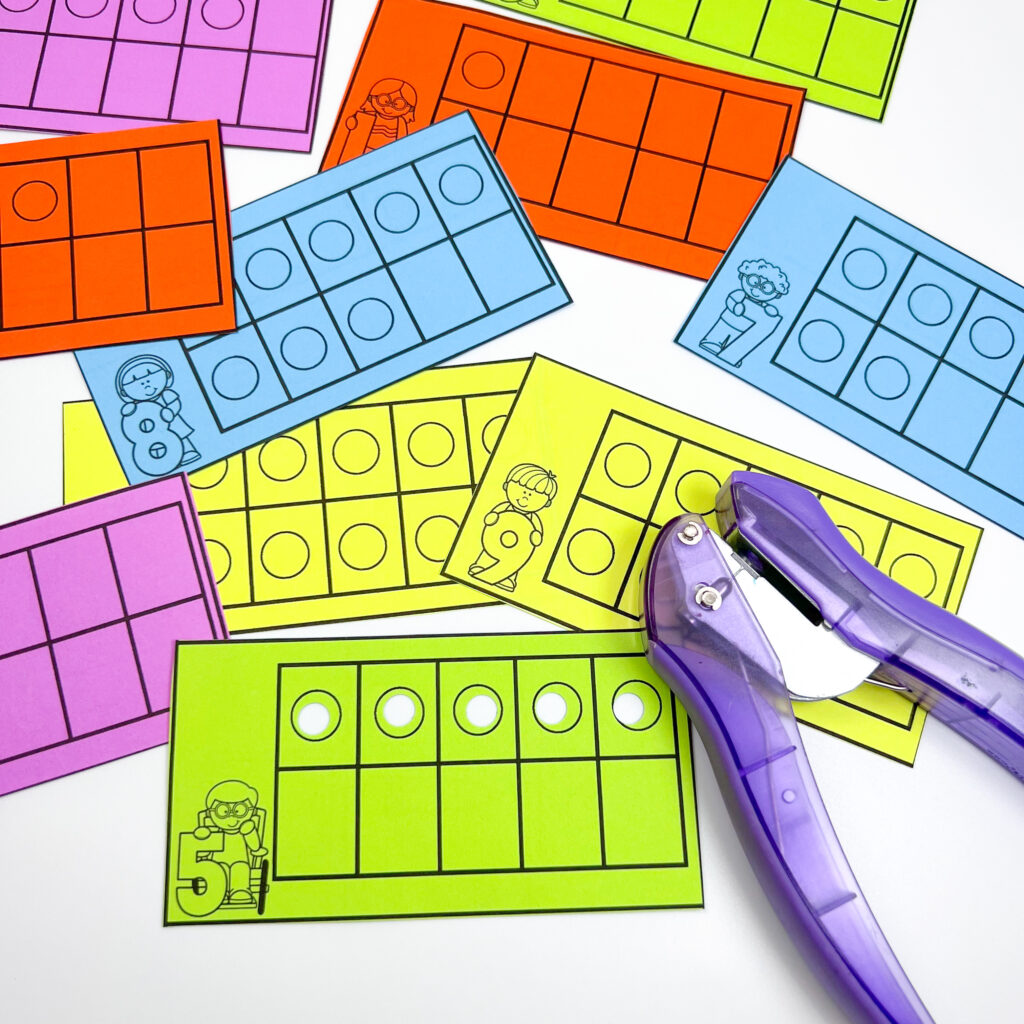 Colorful pieces of paper are being used for a hole punch activity with ten frames