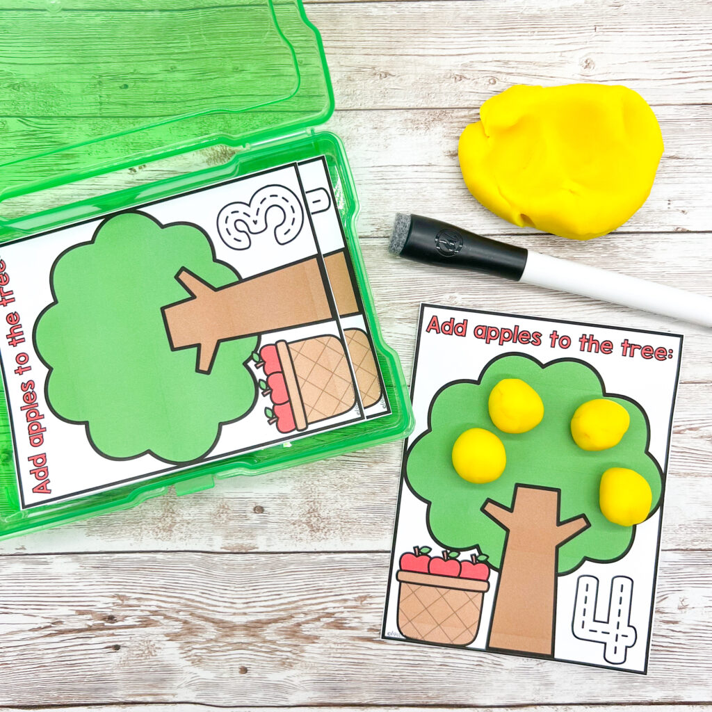 Adding play dough apples to a tree