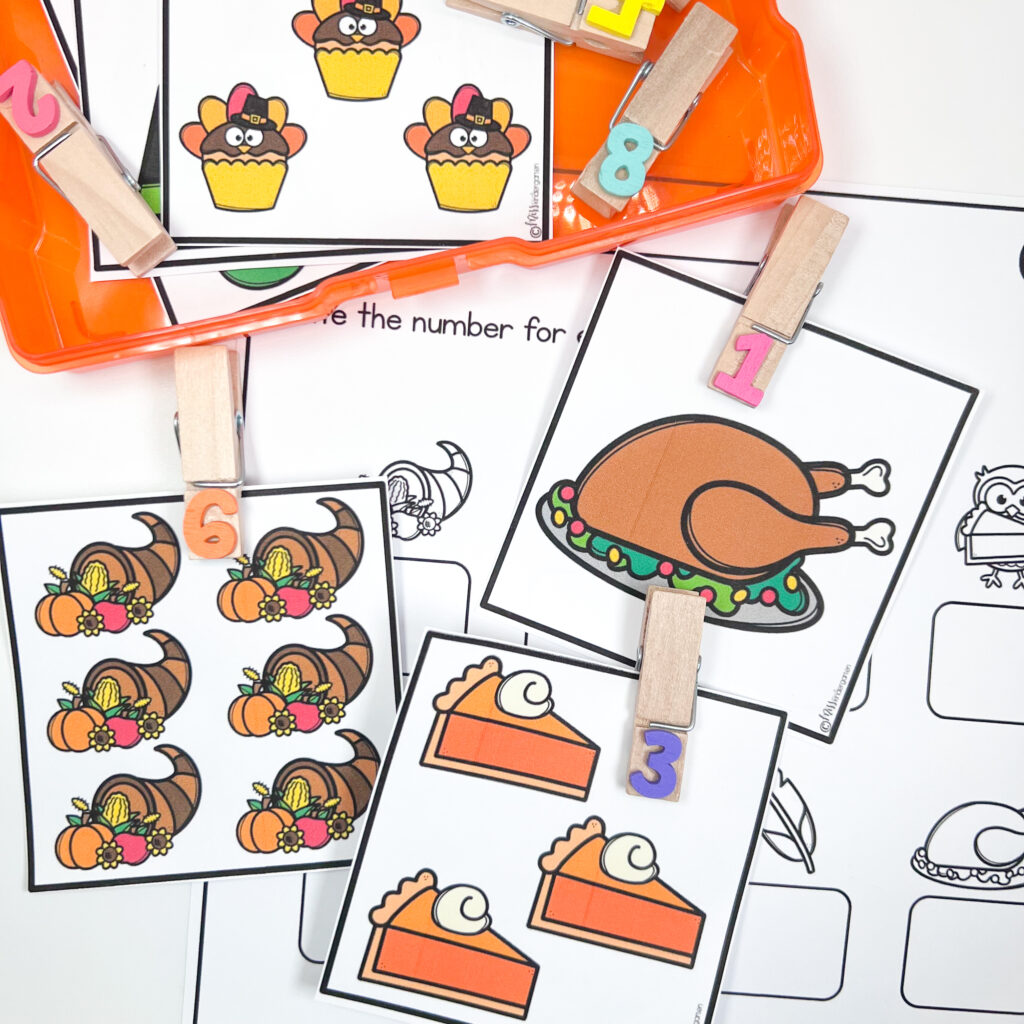Clothespins with numbers have been added to cards with the corresponding number of Thanksgiving objects