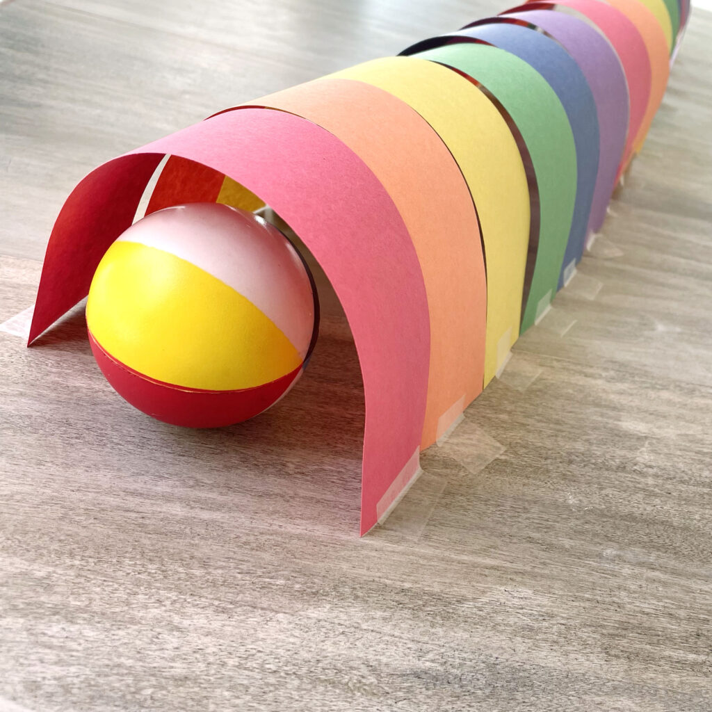 A ball at the entrance of a rainbow paper tunnel