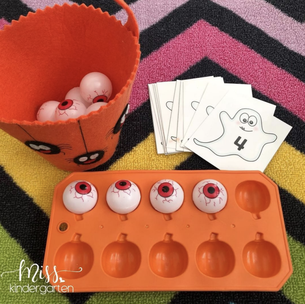 Adding ping pong eyeballs to a pumpkin-shaped ice cube tray