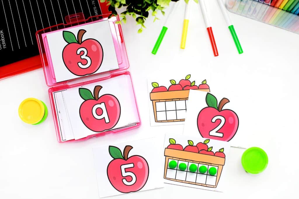 Adding green balls of play dough on an apple themed ten frame task card