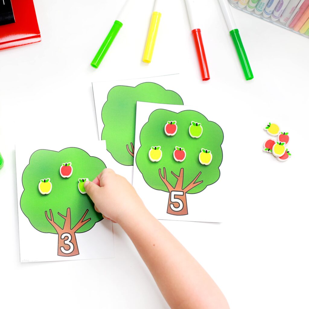 Adding small apple erasers to a numbered tree card