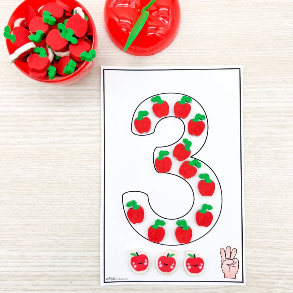 Filling in the number three with apple erasers