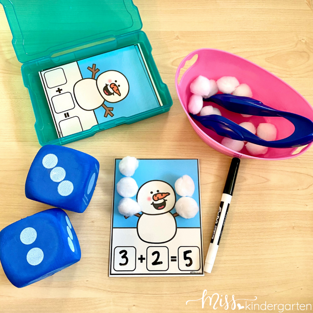 A snowman addition activity with dice and white pom poms